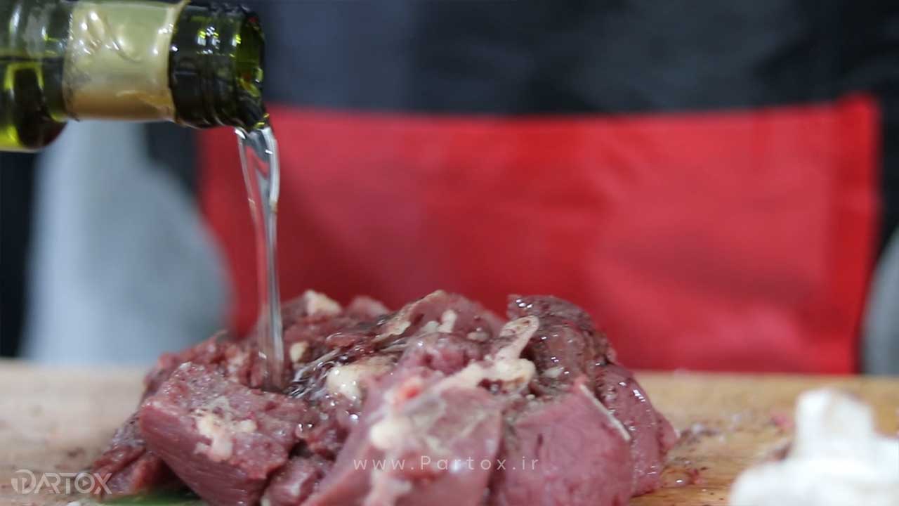 فوتیج اضافه کردن روغن زیتون روی گوشت برای تدوین فیلم آشپزی و رستوران